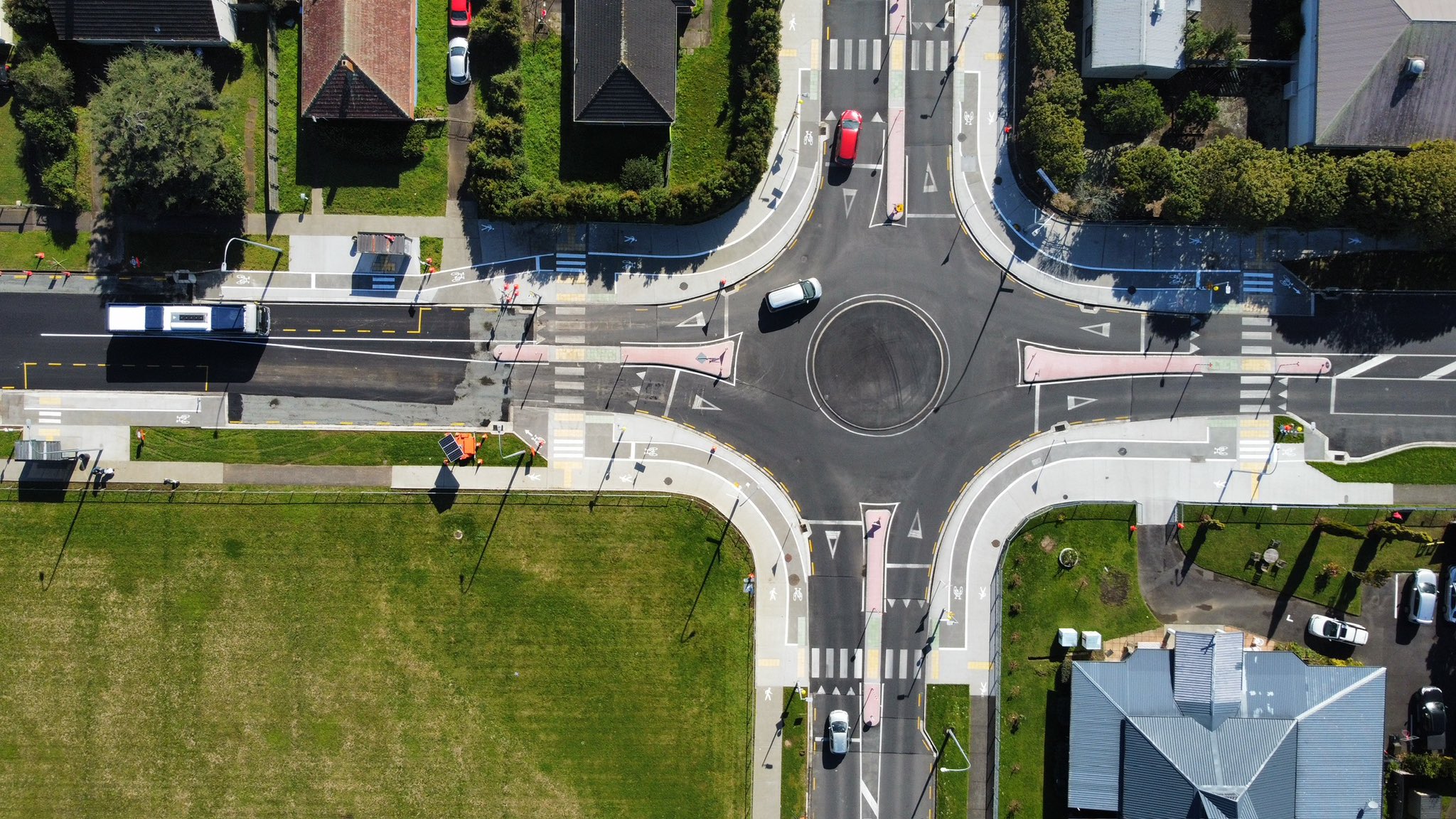 Aerial view of a roundabout shows safe raised crossings for people walking and cycling, as well as a safe dedicated space for people cycling around the edge of the roundabout.