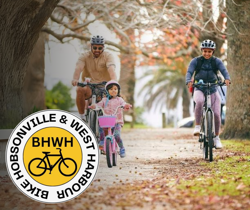 Mum, Dad and young kid ride through autumnal park, with Bike Hobsonville and West Harbour logo