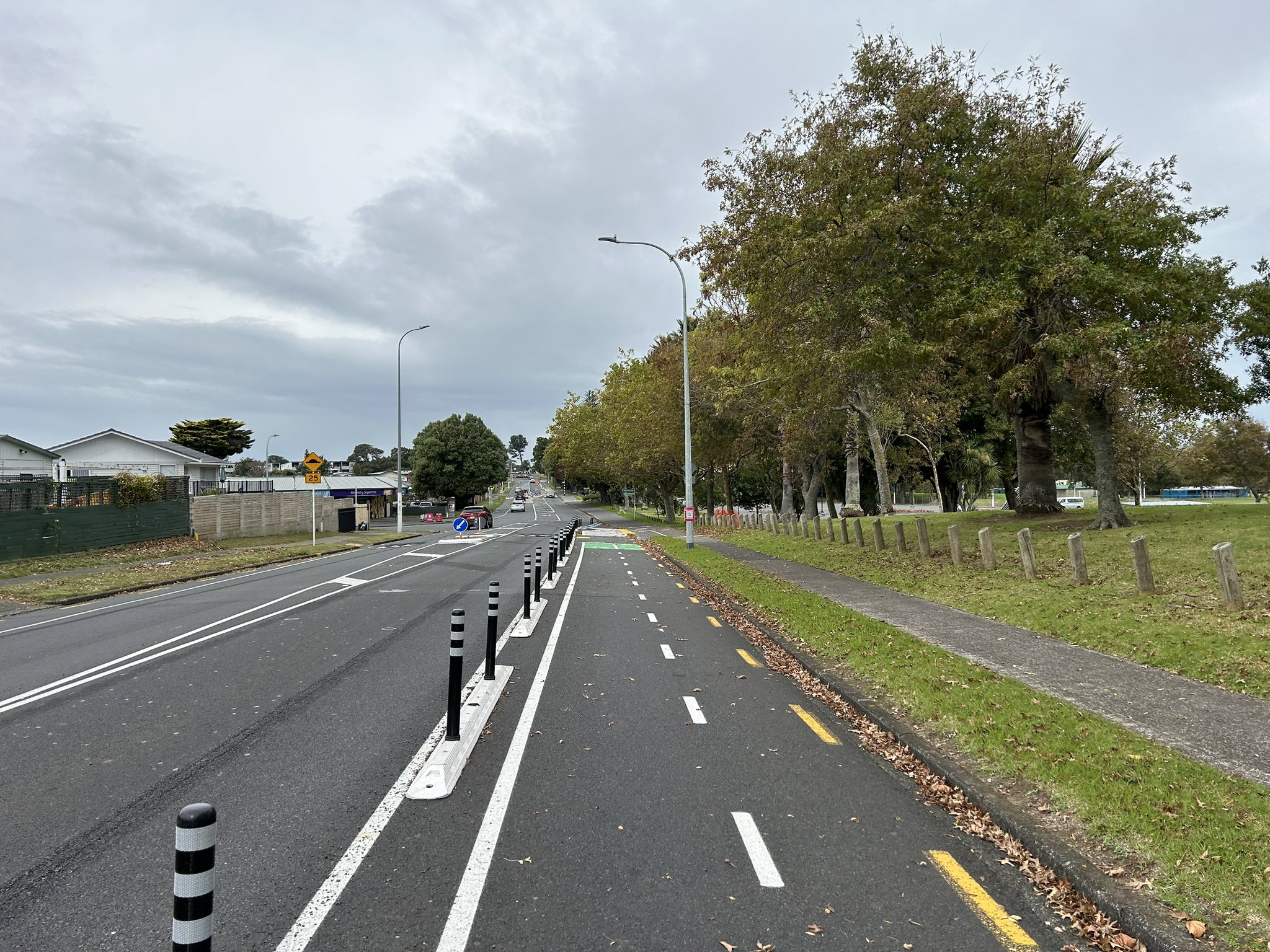 Photo: An on-road bi-directional cycle lane, protected from the traffic lane by small plastic separators and hit sticks. 