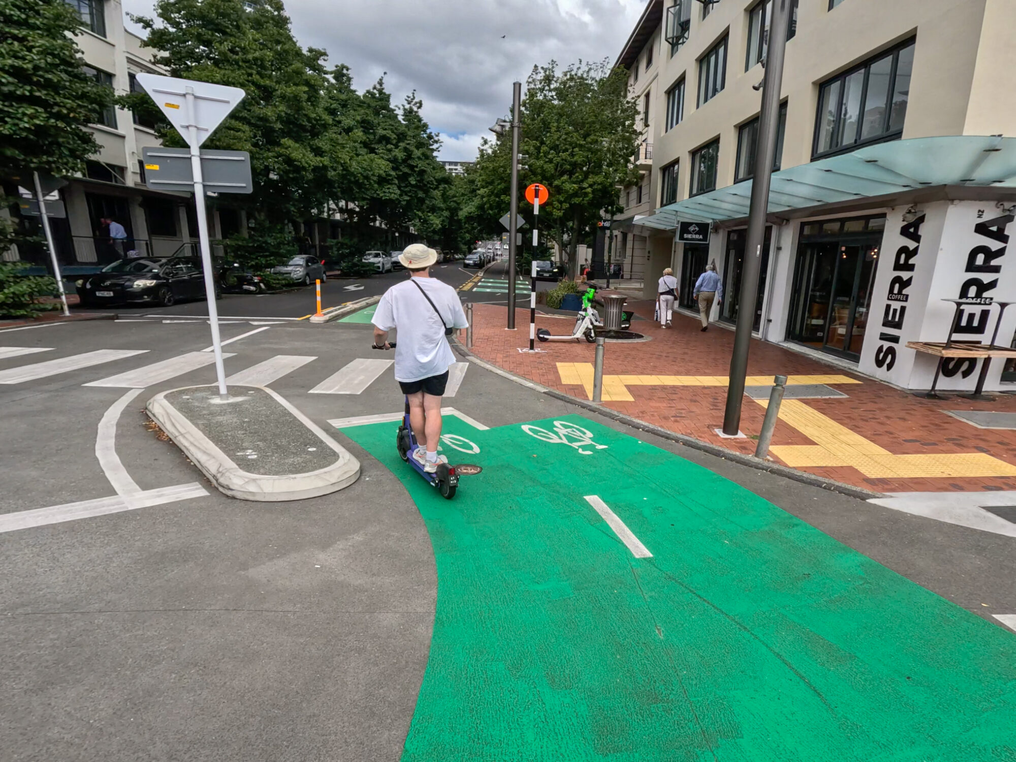 Sam rides a scooter on a city centre cycleway