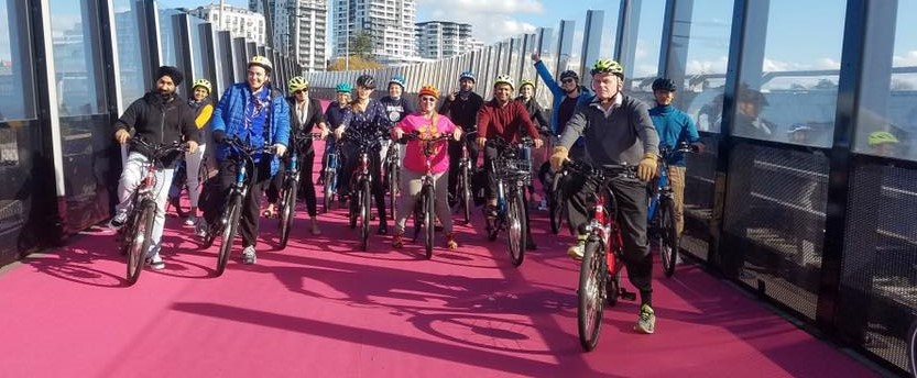 A large group of people on bikes on the pink path