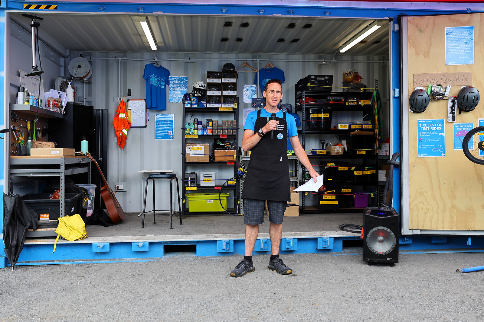 Reesh speaks into a microphone in front of the Bike Hub