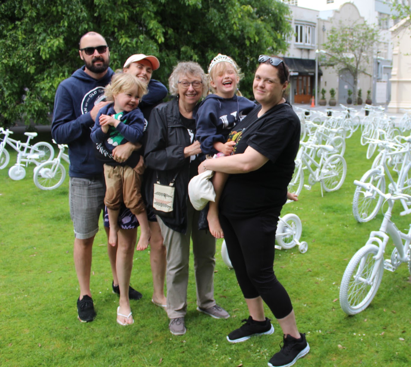 three generations of a family stand in front of the ghost bikes