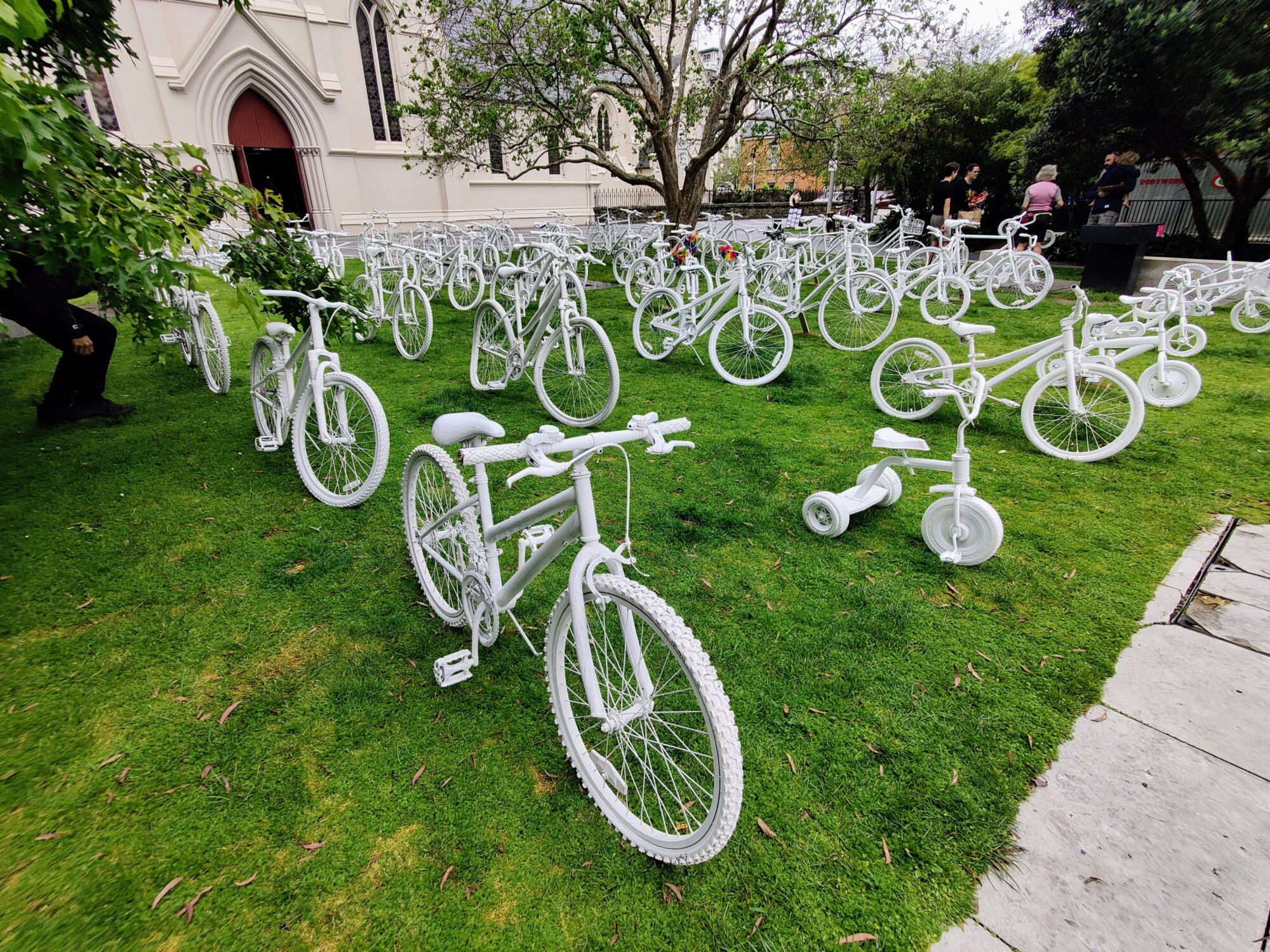 The array of ghost bikes on grass with the church in the background