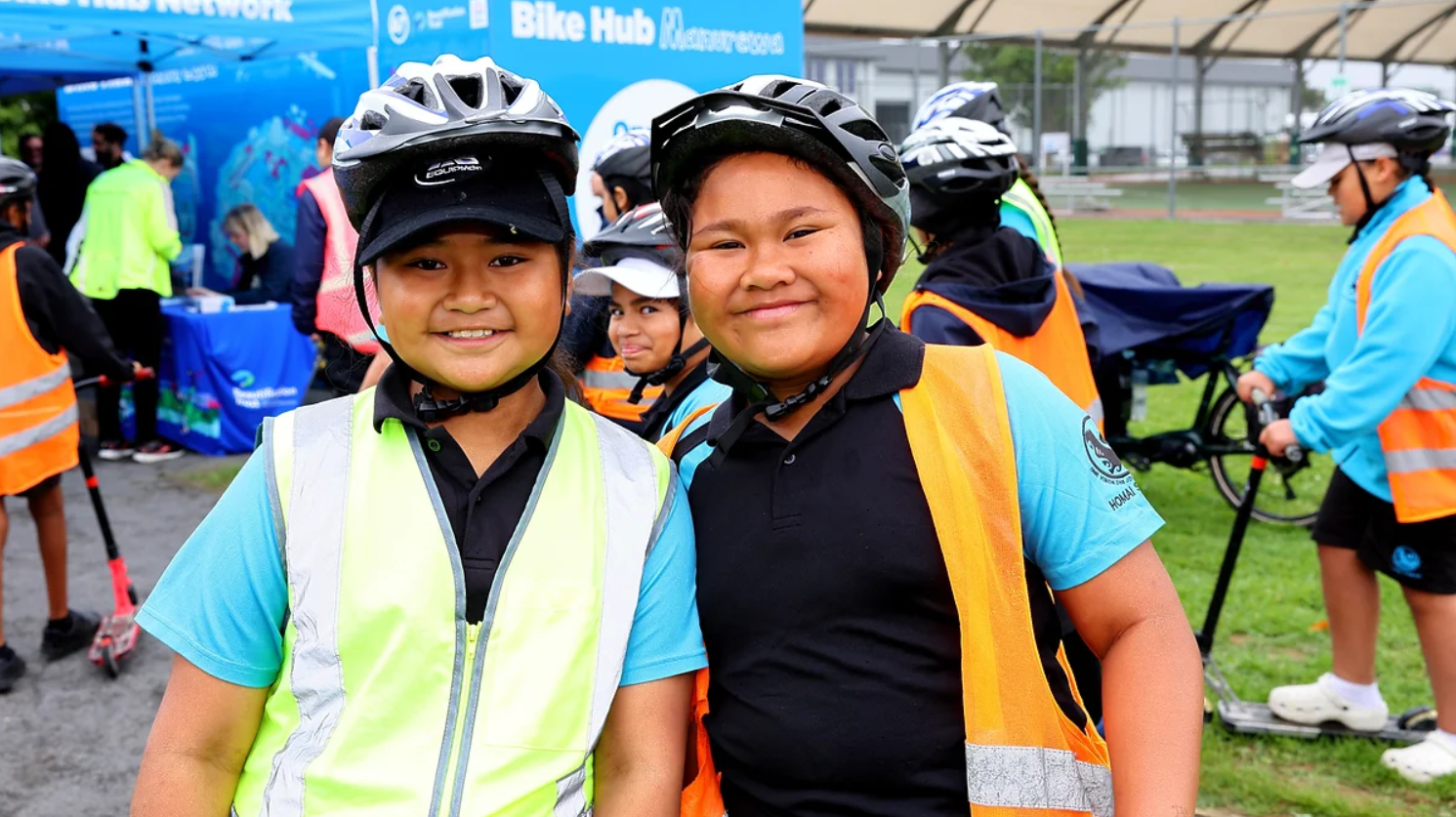 Two kids smiling and wearing helmets